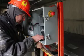 A technician wires the panel to control the Roll Gen system.
