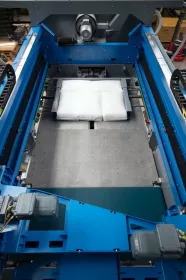 Der neue BEUMER paletpac mit dem Fahrgerüst für den Einzel- oder Doppelabschieber. Die Lagengröße bis 1500 x 1300 Millimeter kann vorbereitet und zum Ablegetisch abgeschoben werden.
