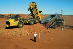 Mobile material feeder feeds overland conveyor in a diamond mine.
